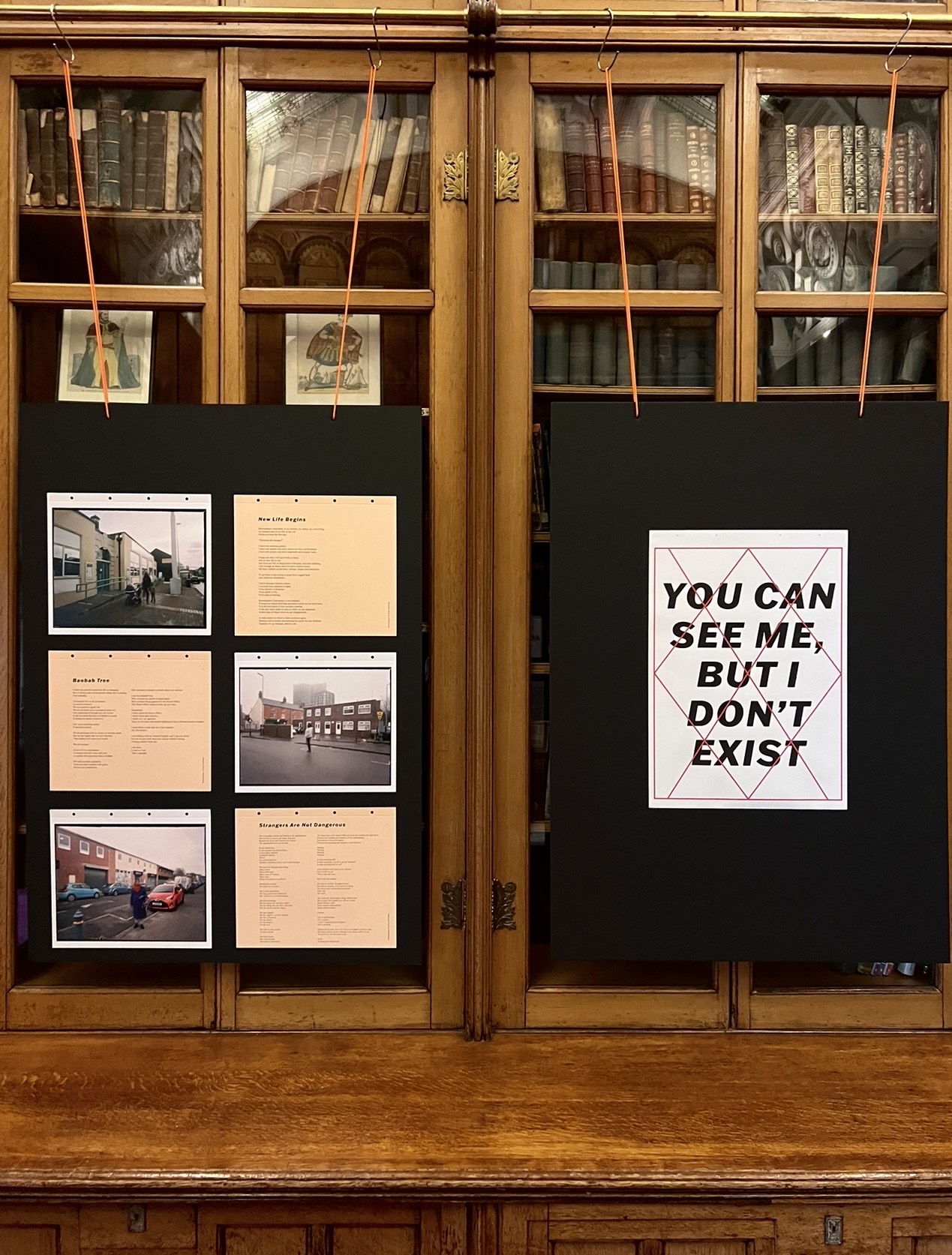 Two black boards propped with images and text mounted on one, and a poster with text mounted on the other