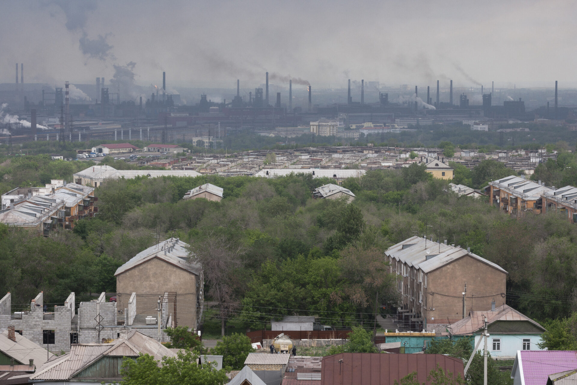 Photo of a residential urban area next to a large polluting industrial site