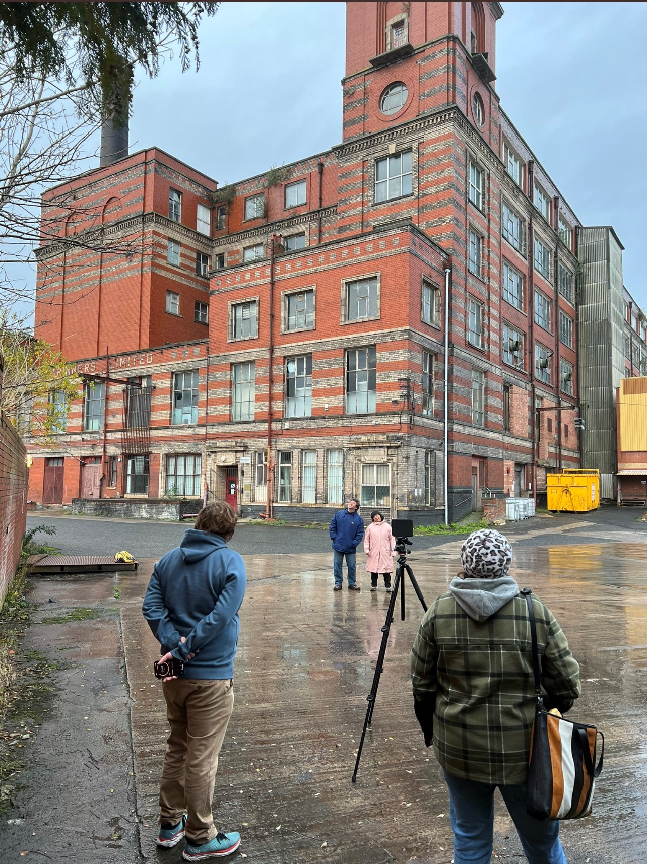 Photographer Alan Gignoux photographing asylum seekers in Manchester in front of a red brick building