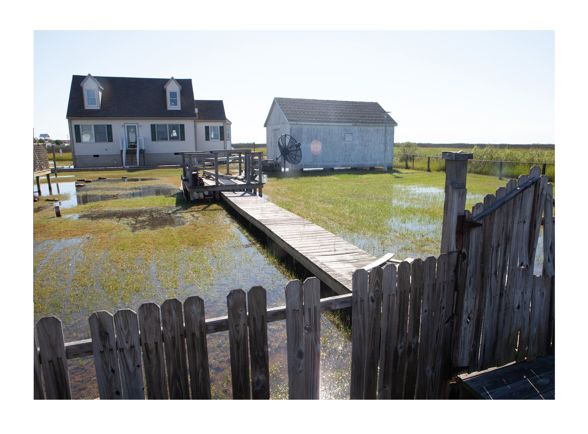 Photograph from Tangier Island zine showing houses surrounded by rising sea waters