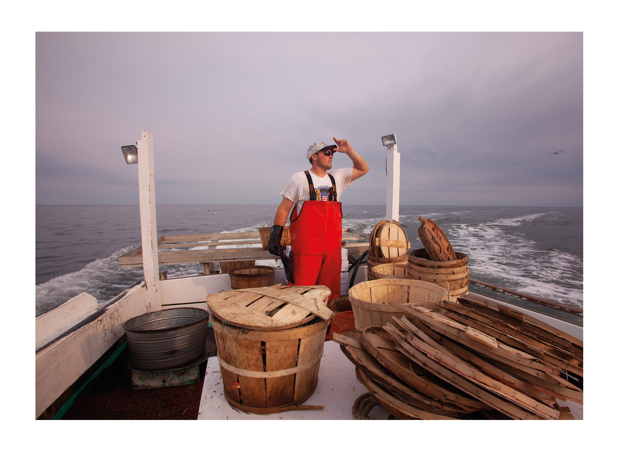 Photograph from Tangier Island photography zine showing a waterman on his boat looking out to sea