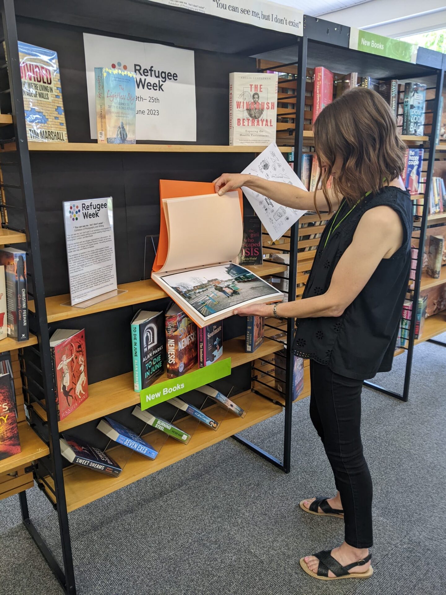 Woman looking through a book on display at a library